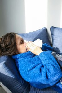 Person on sofa blowing nose