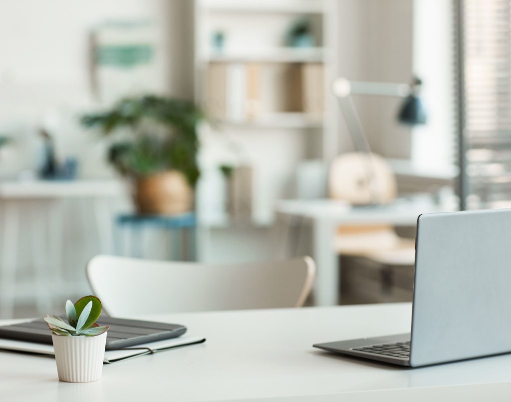 Office environment with desk, laptop and plant to show where the Worker Protection Act may be applicable.