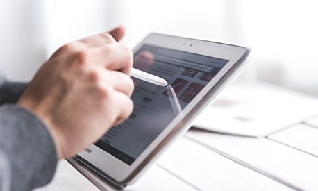 A person holding a tablet computer and using a live chat feature on the tablet screen.