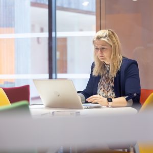Woman sat at desk looking at a laptop screen